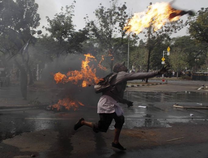 An Indonesian Muslim protester throws a Molotov cocktail towards the police during a protest in front of the U.S. embassy in Jakarta September 17, 2012. Indonesia police used teargas and water cannon on Monday to disperse hundreds of demonstrators who massed outside the U.S. embassy in Jakarta to protest against a film mocking the Prophet Mohammad. REUTERS/Beawiharta (INDONESIA - Tags: POLITICS CIVIL UNREST RELIGION) Published: Zář. 17, 2012, 9:56 dop.