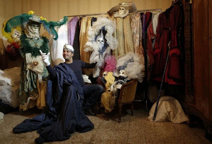 Marco Dilauro smiles as he sits next to his creations, which were used in previous Venice Carnivals January 25, 2013. Dilauro, 43, is a tax collector by day, but his real passion is making masks and costumes for the carnival. A resident of Como, northern Italy, he chooses fabrics, ribbons, lace and costume jewellery to make the period costumes after doing extensive research, and wears them at Carnival, which ends on the day before Ash Wednesday. Picture taken January 25, 2013. REUTERS/Alessandro Bianchi (ITALY - Tags: SOCIETY) Published: Led. 28, 2013, 12:03 dop.