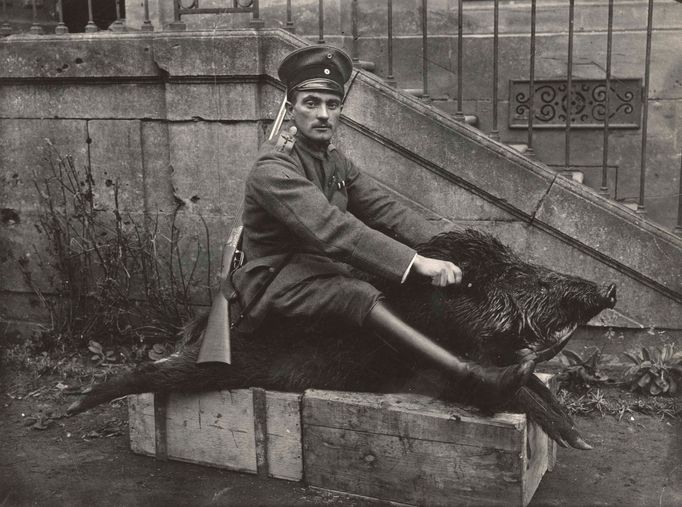 A German Air Force Officer sits astride a dead boar outside a house where he is stationed near the Western Front, in this 1918 handout picture.