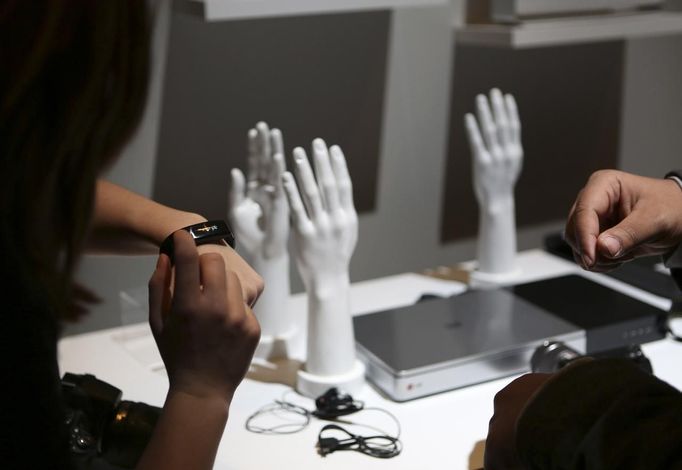 A conference attendee tries out a wearable fitness device at an LG event during the annual Consumer Electronics Show (CES) in Las Vegas, Nevada January 6, 2014.