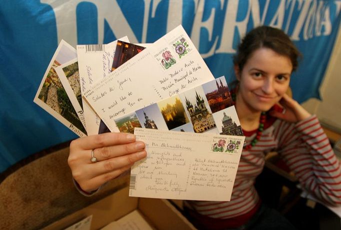 Tereza Mašková drží několik pohledů napsaných včera v Praze. Loni vzniklo v celém Česku asi šest set dopisů. Po celém světě to bylo sto tisíc.