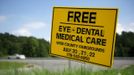 A placard advertises the Remote Area Medical (RAM) clinic in Wise, Virginia July 20, 2012. RAM clinics bring free medical, dental and vision care to uninsured and under-insured people across the country and abroad. The Wise clinic was the 647th RAM expedition since 1985 and drew 1700 patients from 14 states, organizers said. REUTERS/Mark Makela (UNITED STATES - Tags: HEALTH SOCIETY) Published: Čec. 24, 2012, 3:02 odp.