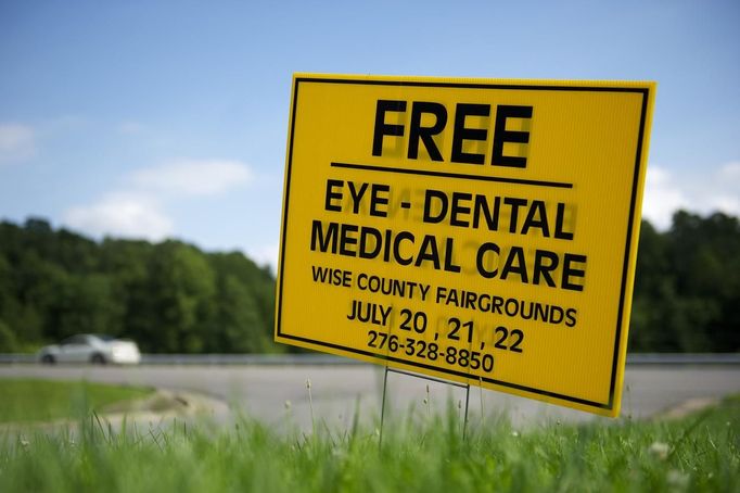 A placard advertises the Remote Area Medical (RAM) clinic in Wise, Virginia July 20, 2012. RAM clinics bring free medical, dental and vision care to uninsured and under-insured people across the country and abroad. The Wise clinic was the 647th RAM expedition since 1985 and drew 1700 patients from 14 states, organizers said. REUTERS/Mark Makela (UNITED STATES - Tags: HEALTH SOCIETY) Published: Čec. 24, 2012, 3:02 odp.