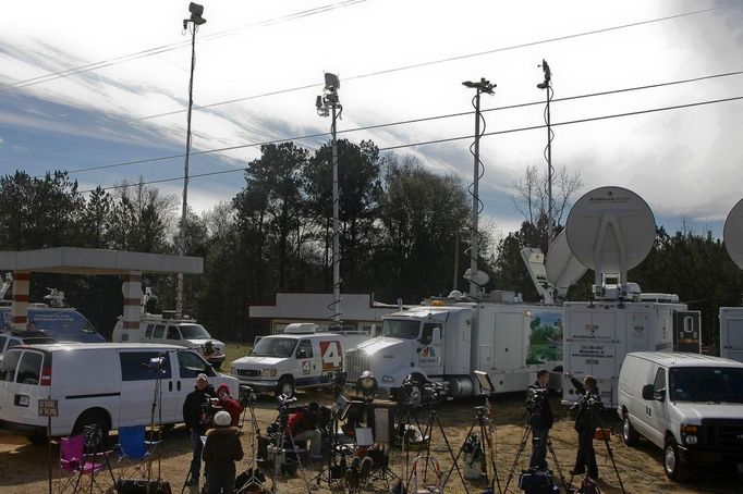 The media contingency near the scene of a shooting and hostage taking near Midland City, Alabama February 1, 2013. Residents in a rural Alabama town prayed on Friday and called for the release of a 5-year-old boy being held captive for a fourth day by a man accused of shooting a school bus driver and then taking the child hostage. REUTERS/Phil Sears (UNITED STATES - Tags: CRIME LAW) Published: Úno. 1, 2013, 9:33 odp.