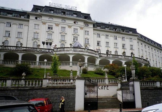 Citujme z webových stránek lázní Jáchymov: "Lázeňský hotel RADIUM PALACE se nalézá uprostřed rozsáhlého lesoparku a působí v zeleni stromů jako krásný perlový náhrdelník. Budova Radium Palace byla vystavěna v roce 1912 na popud Vídeňské akciové společnosti, v jejímž čele stál hrabě Arnošt Tarrouca, na místě původního hostince. Ve své době byl Radium Palace jedním z nejmodernějších lázeňských hotelů ve střední Evropě."