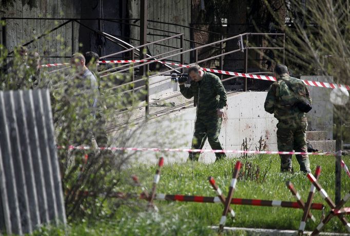 Vyšetřovatelé před vchodem na policejní stanici.