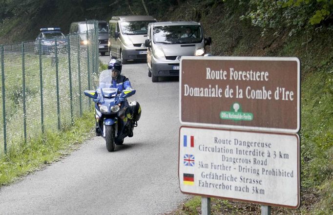 Policista na motorce jede v čele kolony pohřebních vozů, z místa činu odvážela oběti mnohonásobné vraždy.