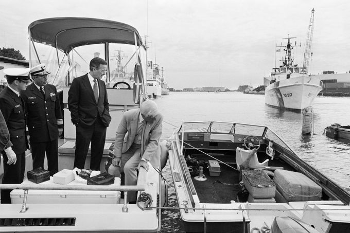 Viceprezident George Bush stojí na lodi zabavené pašerákům drog a dívá se na balíky marihuany a kokainu. Miami, rok 1985