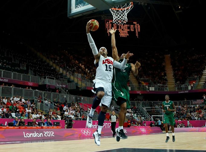 Americký basketbalista Carmelo Anthony smečuje, ač bráněn Nigerijcem Derrickem Obasohanem na OH 2012 v Londýně.