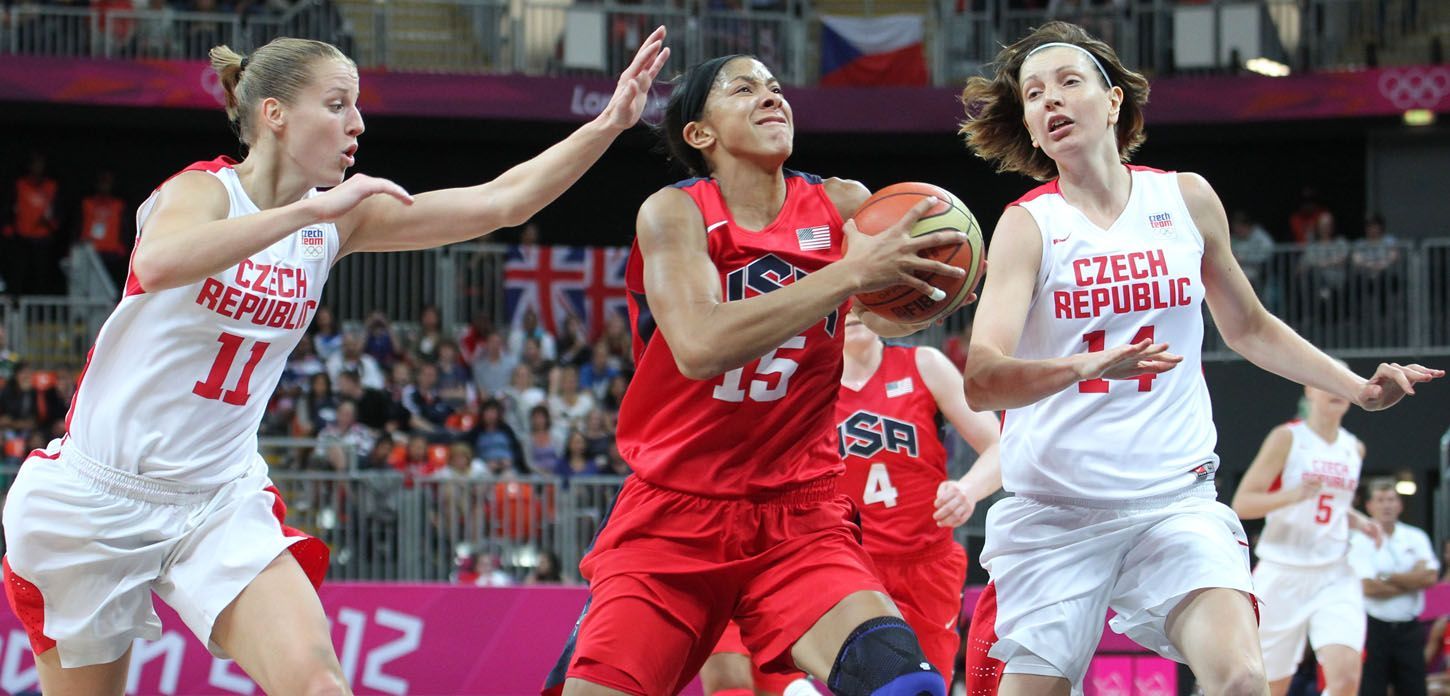 České basketbalistky Kateřina Elhotová (vlevo) a Tereza Pecková se snaží bránit Candace Parkerovou v utkání skupiny A na OH 2012 v Londýně.