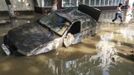 A local resident passes by a damaged car stuck in a flooded street in the town of Krymsk in Krasnodar region, southern Russia, July 8, 2012. Russian President Vladimir Putin ordered investigators to find out if enough was done to prevent 144 people being killed in floods in southern Russia after flying to the region to deal with the first big disaster of his new presidency. REUTERS/Eduard Korniyenko (RUSSIA - Tags: DISASTER ENVIRONMENT POLITICS TRANSPORT) Published: Čec. 8, 2012, 8 dop.