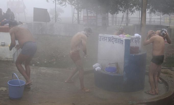 Policemen bathe outside their camp along the banks of the river Ganges on a cold winter morning in the northern Indian city of Allahabad January 7, 2013. The current cold weather in northern India has killed more than 100 homeless people, an aid group said last week. Temperatures in Allahabad have dipped to around 4 degrees Celsius (39.2 degrees Fahrenheit). REUTERS/Jitendra Prakash (INDIA - Tags: ENVIRONMENT) Published: Led. 7, 2013, 8:17 dop.