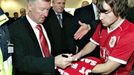 Alex Ferguson je uznávaná celebrita. Po příletu s Manchesterem United do Kodaně se podepisuje fanouškovi na dres.