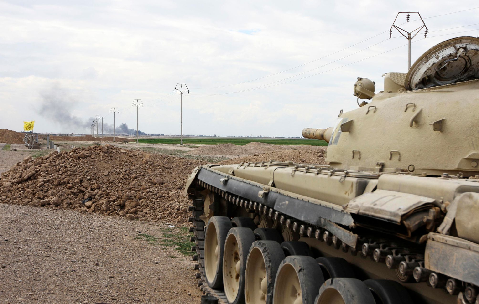 Tank irácké armády před Tikrítem, v pozadí hořící ropné pole Adžíl.