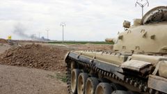 Tank irácké armády před Tikrítem, v pozadí hořící ropné pole Adžíl.