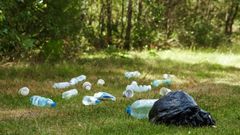 Plastové odpadky odhozené na trávě, plastový odpad, plasty - ilustrační foto.