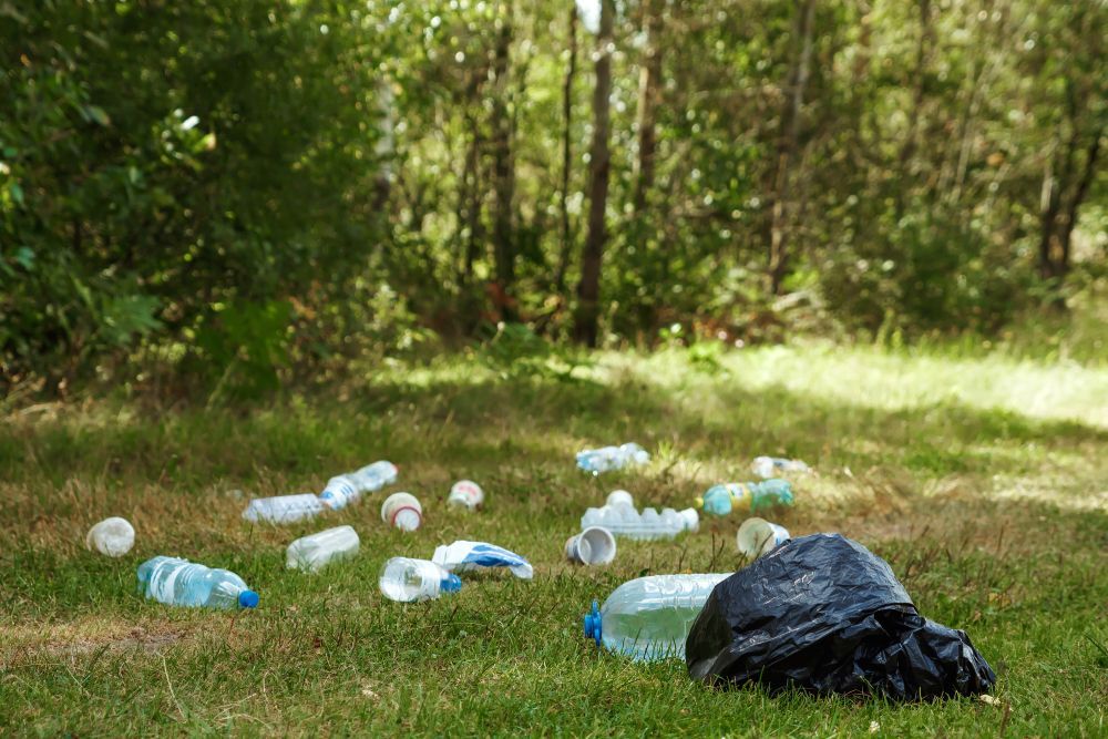 Plastové odpadky odhozené na trávě, plastový odpad, plasty - ilustrační foto.