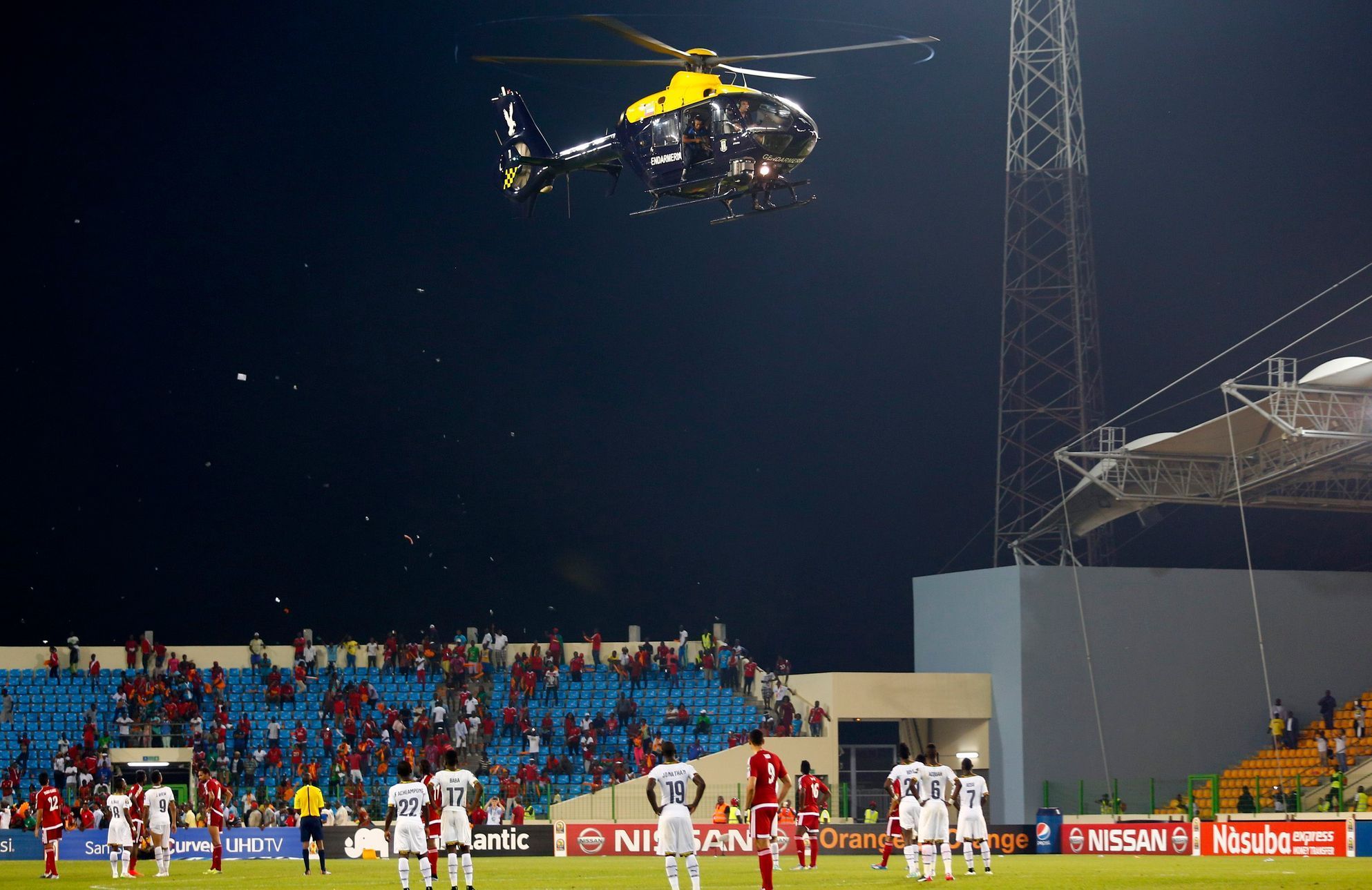 A police helicopter hovers over the pitch as Equitorial Guinea fans throw objects during the 2015 African Cup of Nations semi-final soccer match against Ghana in Malabo