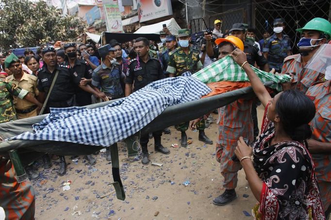 A relative of a garment worker checks a body as she searches for her relative who is missing after the Rana Plaza building, in Savar, 30 km (19 miles) outside Dhaka April 25, 2013. he death toll from a building collapse in Bangladesh has risen to 160 and could climb higher, police said on Thursday, with people trapped under the rubble of a complex that housed garment factories supplying retailers in Europe and North America. REUTERS/Andrew Biraj (BANGLADESH - Tags: DISASTER) Published: Dub. 25, 2013, 5:40 dop.