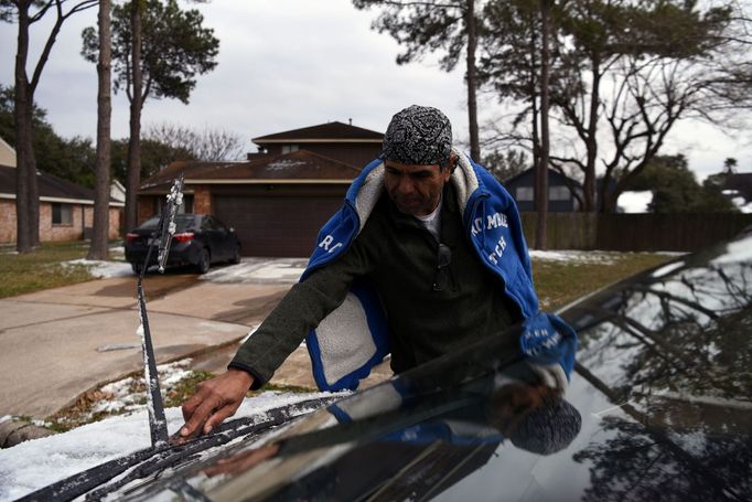 Nezvyklá podívaná v Texasu na jihu USA: muž seškrabává led ze svého auta.