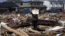 In this photo provided on Friday Feb. 10, 2012 by World Press Photo, the 1st prize People in the News Stories category of the 2012 World Press Photo Contest by Yasuyoshi Chiba, Japan, Agence France-Presse shows the aftermath of the tsunami in Japan, April 3, 2011. Chieko Matsukawa shows her daughter's graduation certificate as she finds it in the debris in Higashimatsushima city, Miyagi prefecture, Japan.