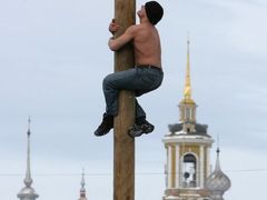 Muž leze během oslav Maslenice na dřevěný sloup ve starobylém městě Suzdal severně od Moskvy.