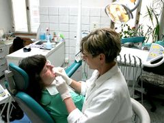 Mudr. Eva Sládková odstraňuje starou výplň zubu pacientky.