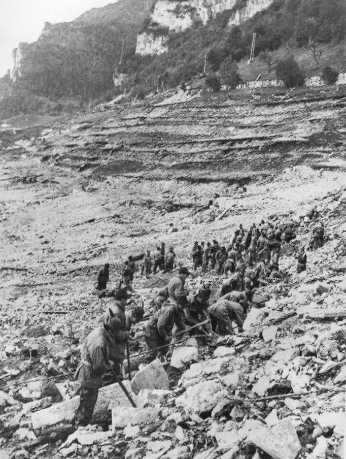 Záchranáři hledají v troskách těla obětí (10. října 1963).