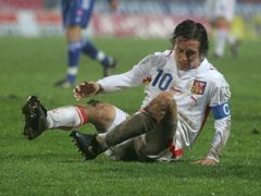 Kapitán reprezentace Tomáš Rosický se zvedá z mokrého trávníku.