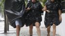 As Tropical Storm Isaac moves over the island, Allen Weeks (L) Julie Beard ( C ) and Sherry Wright make their way home from a bar wearing garbage bags to protect themselves against the rain in Key West, August 26, 2012. Tropical Storm Isaac lashed south Florida with winds and heavy rain on Sunday after battering the Caribbean, disrupting plans for the Republican National Convention in Tampaand threatening to interrupt about half of U.S. offshore oil output. REUTERS/Andrew Innerarity (UNITED STATES - Tags: ENVIRONMENT DISASTER) Published: Srp. 26, 2012, 11:38 odp.