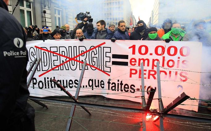 Arcelor Mittal workers from the Liege site hold a banner reading "No steel industry, 10,000 jobs lost, Politicians, what are you doing?", during a demonstration outside Prime Minister Elio Di Rupo's office where a political meeting is taking place,in Brussels January 25, 2013. ArcelorMittal, the world's largest steel producer, plans to shut a coke plant and six finishing lines at its site in Liege Belgium, affecting 1,300 employees, the group said on Thursday. REUTERS/Yves Herman (BELGIUM - Tags: BUSINESS CIVIL UNREST EMPLOYMENT) Published: Led. 25, 2013, 12:49 odp.