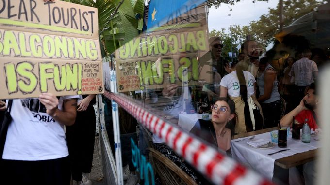 Červencový protest místních proti masovému turismu v Barceloně. Cedule nabádá turisty, aby zkusili "balconing" - tedy oblíbenou aktivitu skoku z balkonu do bazénu, která je ale velmi nebezpečná.