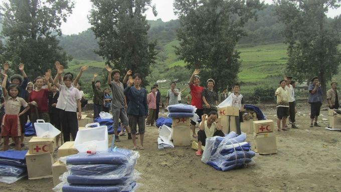 Lidé, kteří ztratili domov kvůli povodním, dostávají příděl jídla.
