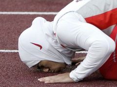 "Díky Alláhu" Bahrajnská běžkyně Ruqaya Al-Ghasara líbá trať na které vyhrála závod na 200 metrů.