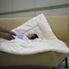 A ward official takes care of a baby who was abandoned in a "baby box" at Joosarang church, before the baby's medical examination at a children's hospital in Seoul September 19, 2012. Pastor Lee Jong-rak of the church, who runs a "baby box" where mothers can leave unwanted infants, has seen a sharp increase in the number of newborns being left there because, the pastor says, of a new law aimed protecting the rights of children. South Korea is trying to shed a reputation of being a source of babies for adoption by people abroad. It is encouraging domestic adoption and tightening up the process of a child's transfer from birth mother to adoptive parents. Picture taken September 19, 2012. REUTERS/Kim Hong-Ji (SOUTH KOREA - Tags: SOCIETY) Published: Říj. 7, 2012, 6:49 dop.