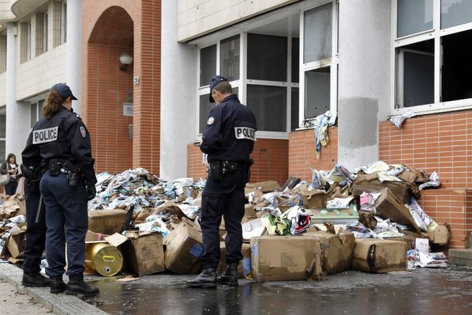 Pařížská policie před vypálenou redakcí magazínu Charlie Hebdo.