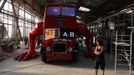 Artist David Cerny walks at a factory hall in Prague as he works on his project to transform a London bus into a robotic sculpture July 2, 2012. The bus, which Cerny hopes could become an unofficial mascot of the London 2012 Olympic Games, does push-ups with the help of an engine powering a pair of robotic arms and the motion is accompanied by a recording of sounds evoking tough physical effort. It will be parked outside the Czech Olympic headquarters in London for the duration of the Games. Picture taken July 2, 2012. REUTERS/Petr Josek (CZECH REPUBLIC - Tags: SOCIETY SPORT OLYMPICS TRANSPORT) Published: Čec. 22, 2012, 5:57 odp.