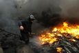 An anti-government protester advances through a burning barricade in Kiev's Independence Square February 20, 2014. Ukrainian protesters hurling petrol bombs and paving st