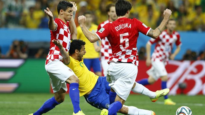 Brazil's Fred (C) is fouled by Croatia's Dejan Lovren (L) during the 2014 World Cup opening match between Brazil and Croatia at the Corinthians arena in Sao Paulo June 12