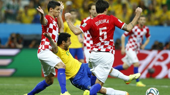 Brazil's Fred (C) is fouled by Croatia's Dejan Lovren (L) during the 2014 World Cup opening match between Brazil and Croatia at the Corinthians arena in Sao Paulo June 12