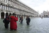 Někteří turisté si dnešní benátskou záplavu užívají.