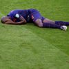 Martins Indi of the Netherlands lies injured on the pitch after being fouled by Australia's Cahill during their 2014 World Cup Group B soccer match at the Beira Rio stadium in Porto Alegre