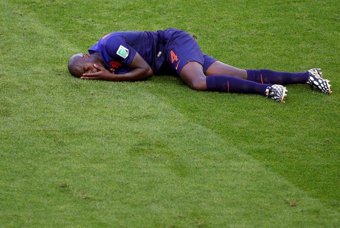 Bruno Martins Indi of the Netherlands lies injured on the pitch after being fouled by Australia's Tim Cahill during their 2014 World Cup Group B soccer match at the Beira