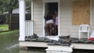 Residents stand on the porch of their home bolstered with sandbags to hold back flood waters in the aftermath of Hurricane Isaac in Reserve, Louisiana August 30, 2012. Isaac, downgraded to a tropical storm, has drenched southeastern Louisiana and Mississippi with heavy rainfall while a significant storm surge continued, the U.S National Hurricane Center said. REUTERS/Peter Forest (UNITED STATES - Tags: ENVIRONMENT DISASTER) Published: Srp. 30, 2012, 11:59 odp.