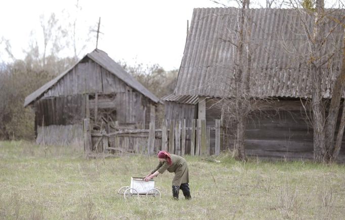 A Belarussian villager pushes a trolley containing products purchased from a mobile shop on the eve of Radunitsa in the abandoned village of Tulgovichi