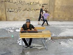 Syrský chlapec tam, kde má být. Ve školní lavici. Jen místo štětce třímá kalašnikov.