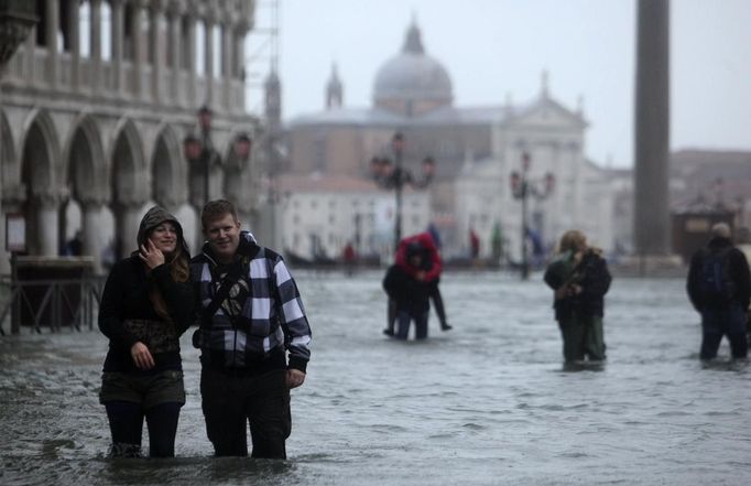 People walk through a flooded street during a period of seasonal high water in Venice November 11, 2012. The water level in the canal city rose to 149 cm (59 inches) above normal, according to local monitoring institute Center Weather Warnings and Tides. REUTERS/Manuel Silvestri (ITALY - Tags: ENVIRONMENT SOCIETY TPX IMAGES OF THE DAY) Published: Lis. 11, 2012, 2:20 odp.