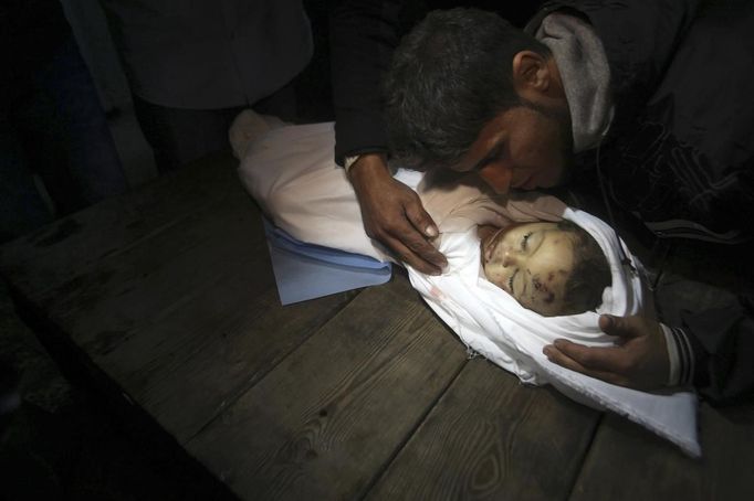 A relative mourns over the body of Palestinian baby girl Hanen Tafish who according to hospital officials was killed in an Israeli air strike in Gaza City November 15, 2012. Two rockets fired from the Gaza Strip targeted Tel Aviv on Thursday in the first attack on Israel's commercial capital in 20 years, raising the stakes in a showdown between Israel and the Palestinians that is moving towards all-out war. Earlier, a Hamas rocket killed three Israelis north of the Gaza Strip, drawing the first blood from Israel as the Palestinian death toll rose to 16, five of them children, one of them Tafish. REUTERS/Ali Hassan (GAZA - Tags: POLITICS CIVIL UNREST) Published: Lis. 15, 2012, 8:48 odp.