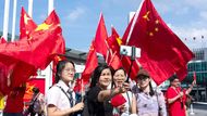 V Hongkongu si lidé pořizují selfie s čínskými vlajkami. Oslavy Národního dne tu doprovází hudební programy, pouliční slavnosti i ohňostroje.