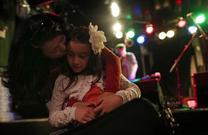 Mercedes Santos kisses her daughter Ava after her performance at the "Beat Kitchen" in Chicago, Illinois, February 24, 2013. Santos and her partner Theresa Volpe are a same-sex couple raising two of their biological children as they struggle to get same-sex marriages passed into law in Illinois. Picture taken February 24, 2013. REUTERS/Jim Young (UNITED STATES - Tags: SOCIETY) Published: Bře. 25, 2013, 6:06 odp.